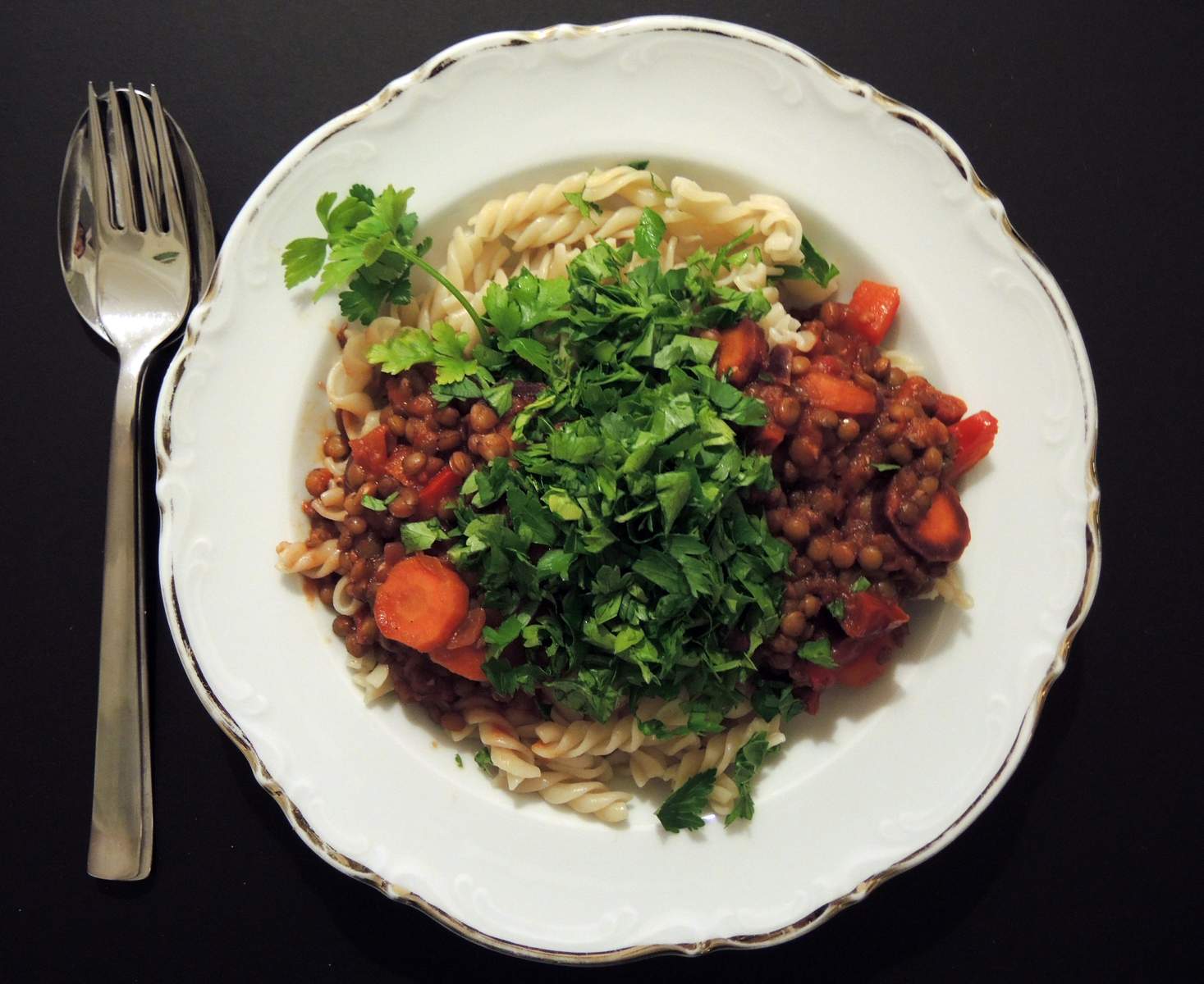 Vegane Linsen-Bolognese-Pasta mit Gemüse und Kräutern Bild